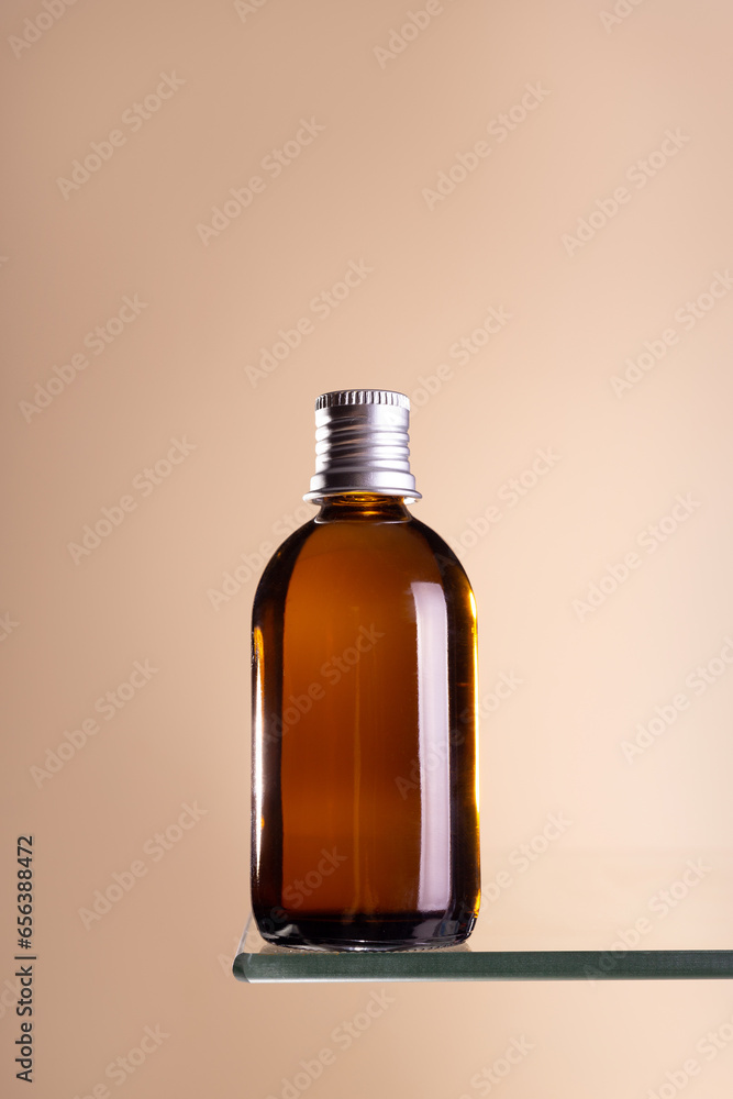 Brown glass bottle with silver cap mock ap on a beige background. Anti aging concept, hyaluronic acid and collagen with peptides . Brown glass bottle with silver cap mock ap on a beige background. Anti aging concept, hyaluronic acid and collagen with peptides .
