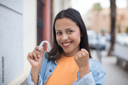 hispanic woman showing a dental retainer