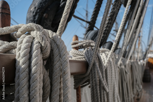 Принти на полотні Ropes, rigging and tackles, hawsers on outdoor wooden deck of windjammer sailing