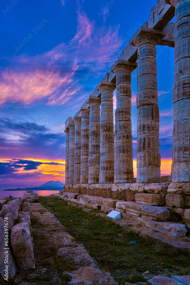 Sunset sky and ancient ruins of temple of Poseidon, Sounion, Greece