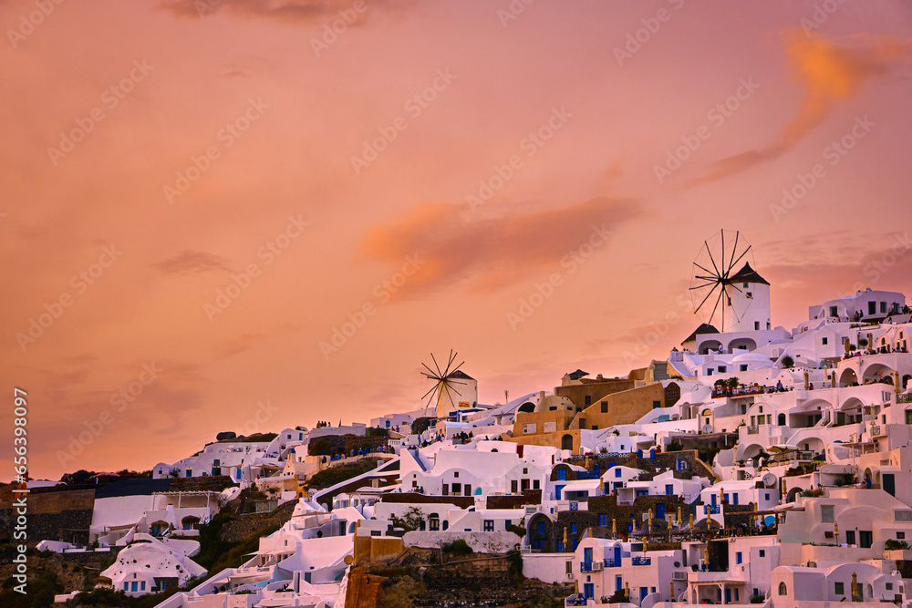 Oia village, windmills, Santorini island, Greece at colorful sunset