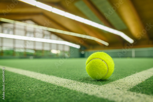 Tennisball liegt auf einem Tennisplatz in einer Tennishalle photo