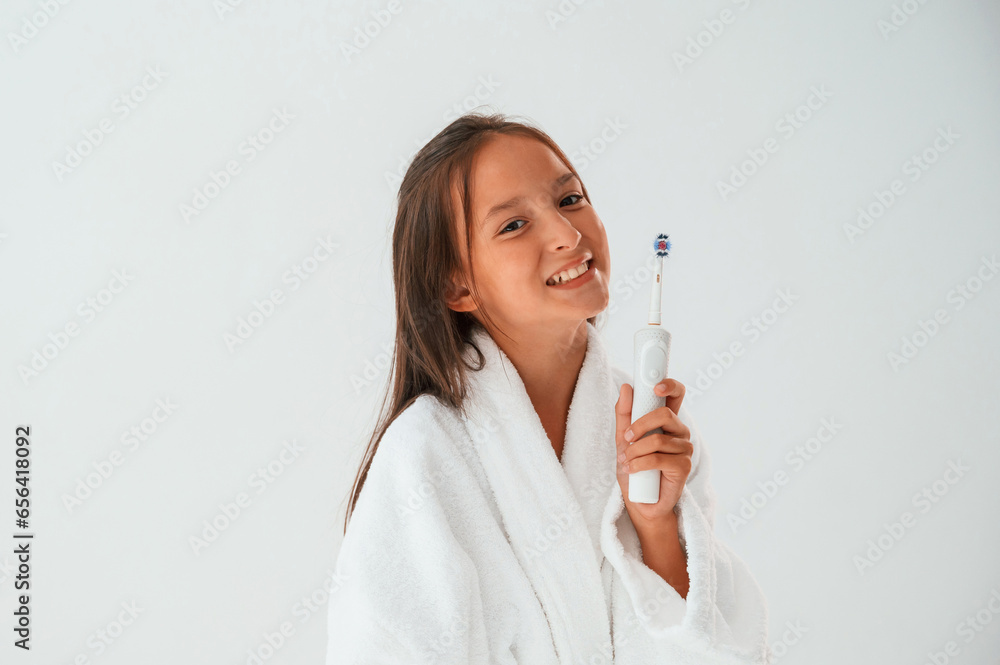 Using the toothbrush. Conception of beauty and self care. Young girl is in the studio Using the toothbrush. Conception of beauty and self care. Young girl is in the studio