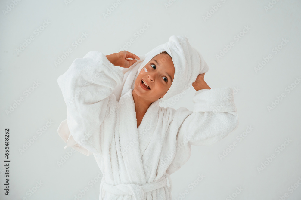 Having fun. With towel on head. Conception of beauty and self care. Young girl is in the studio Having fun. With towel on head. Conception of beauty and self care. Young girl is in the studio