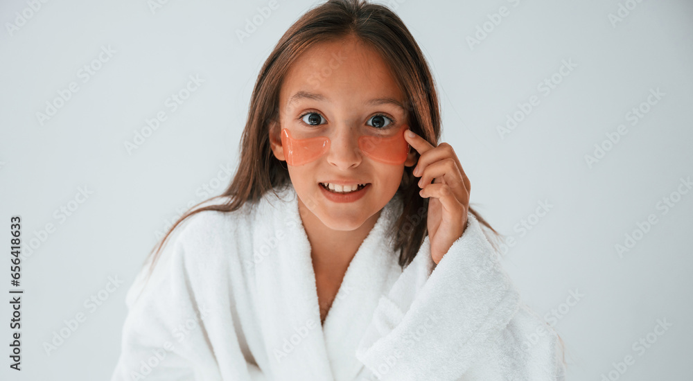 Positive look. With eye patches. Conception of beauty and self care. Young girl is in the studio Positive look. With eye patches. Conception of beauty and self care. Young girl is in the studio