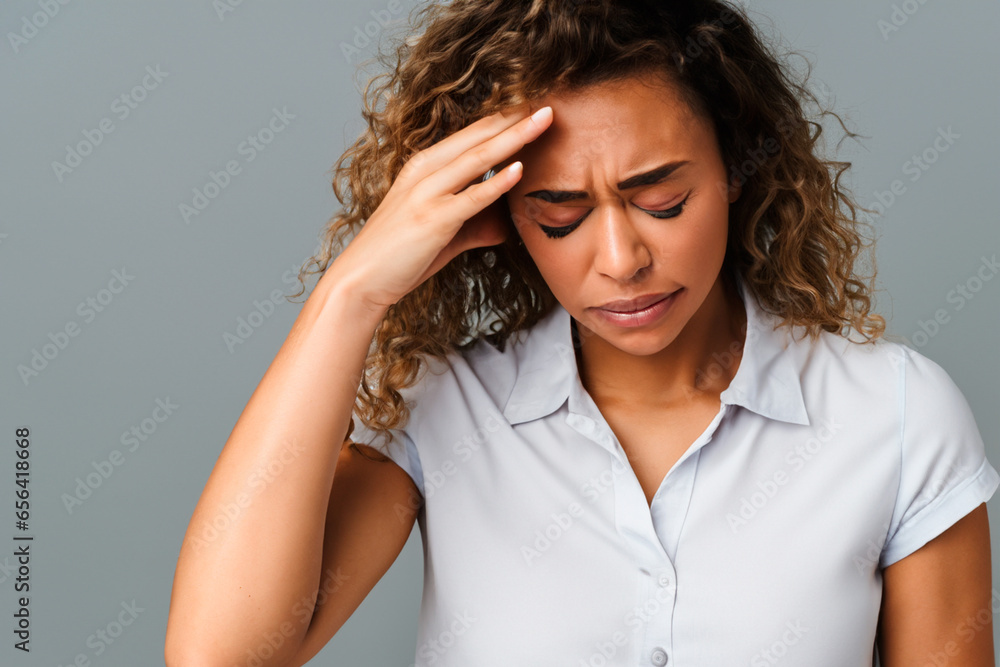 Portrait of a beautiful woman with pale wavy hair in a white short-sleeved shirt with a severe headache Portrait of a beautiful woman with pale wavy hair in a white short-sleeved shirt with a severe headache