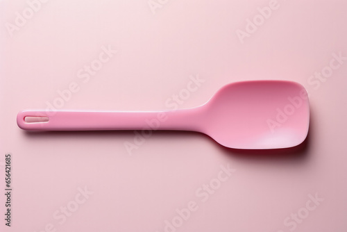 A minimalist vibrant pink spatula isolated on a white background 