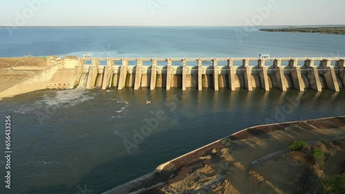 Dolly Slide across front of concrete dam wall at full capacity during sunset photo