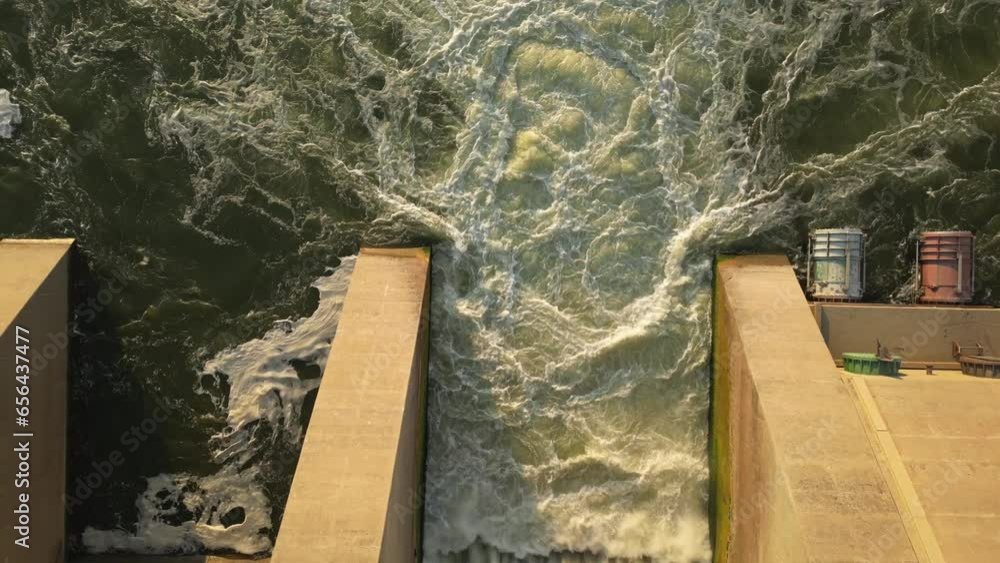 Vidéo Stock Top view of churning muddy water. Rise up to reveal Dam