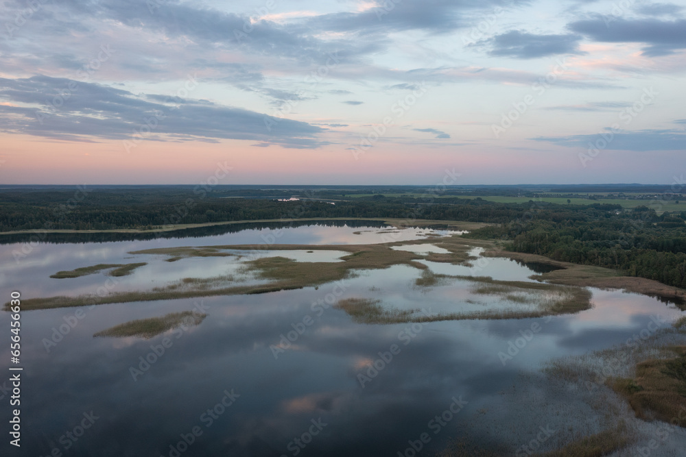 Aerial view on Braslav lake  Snudy, Belarus. Summer sunset on lake Snudy, small islands on lake of dry reed. The sky is reflected from the surface of the lake water.