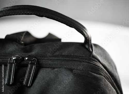 Voluminous black backpack and zipper from the lock close-up