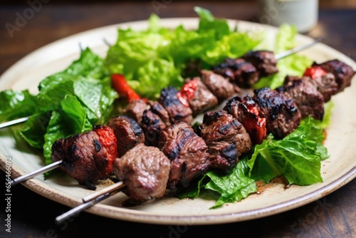 lamb kebabs on bed of leafy greens