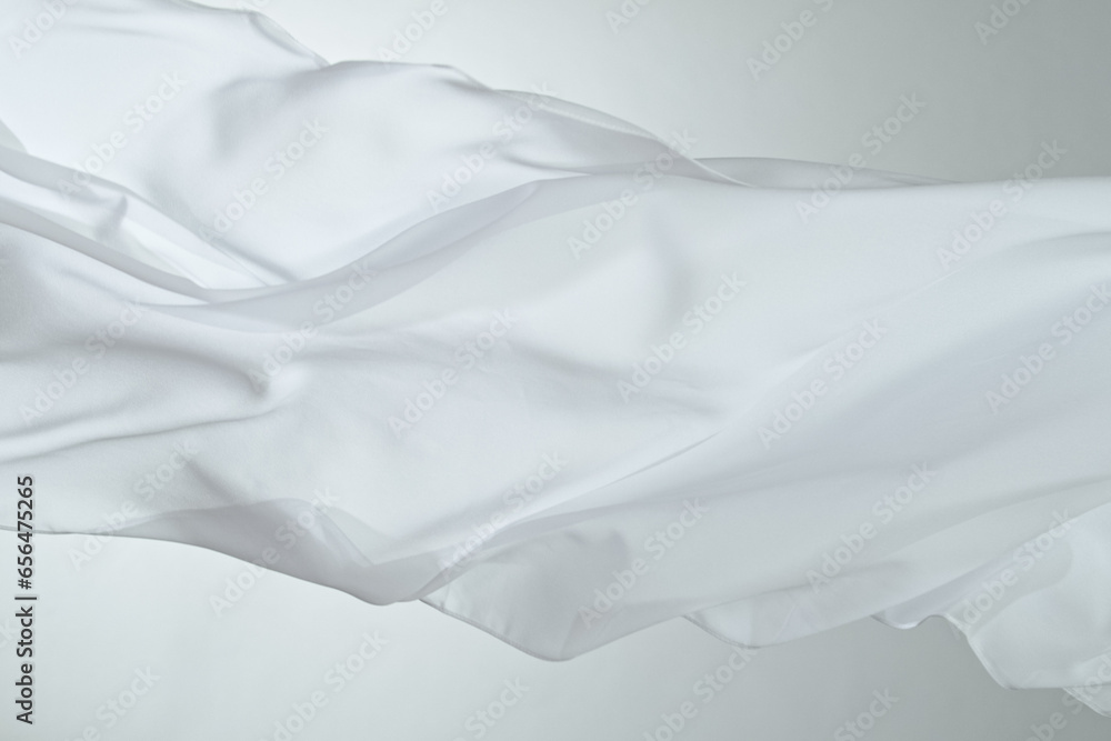Obraz premium Closeup of rippled white silk fabric, color fabric draped in soft waves empty bed sheet