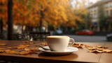 Cup of coffee on the table with autumn leaves on blurred background