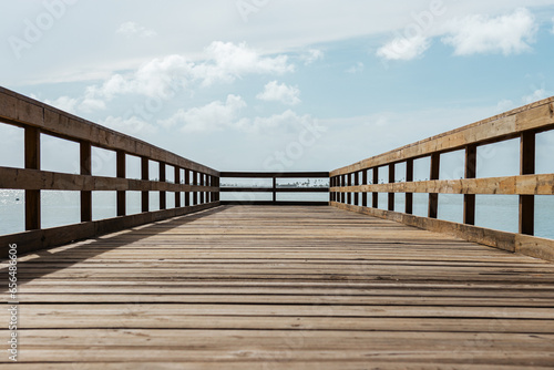 perspective of a wooden bridge in a coast  with a cloudy sky from puerto rico  © emaotx