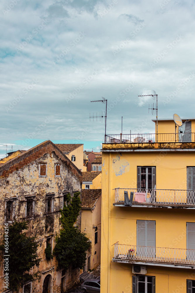 Ancient houses on the island of Corfu. Panoramic view of a southern European city. Street landscape in Greece. Vertical photo for social media.