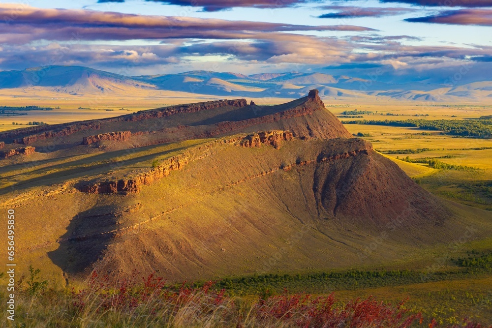Awe landscape of sunny sunset on Sunduki mountain range at early autumn day in Khakassia. View on Chest rock. Location in valley of the Bely Iyus River in republic of Khakassia, Russia - obrazy, fototapety, plakaty 