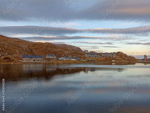 Fototapeta Naklejka Na Ścianę i Meble -  Honningsvag town reflected in Andrevatn lake, Mageroya Island, Norway