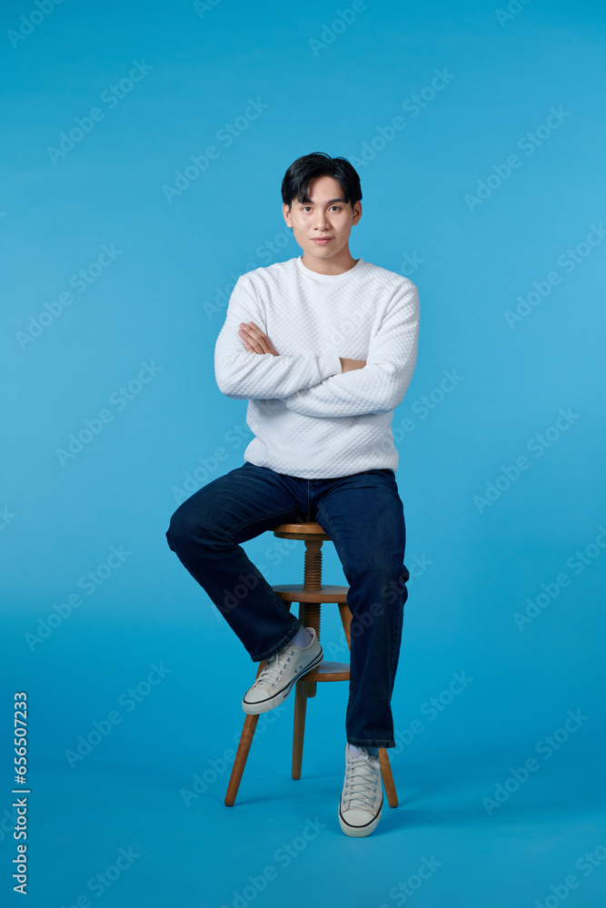 © makistock - Happy smart casual man smiling with his hands folded while sitting on a chair