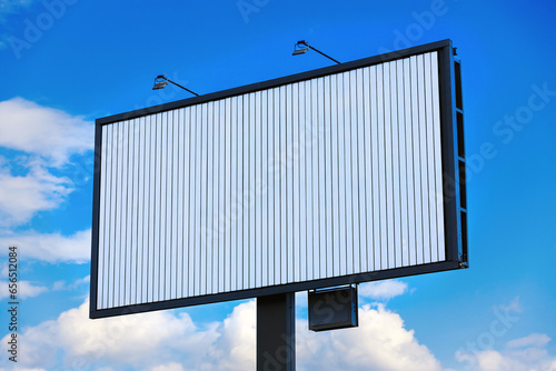 Blank white billboard mockup at grey frame. Trivision against blue sky background. A Trivision, also called three-message sign. Outdoor advertising poster photo