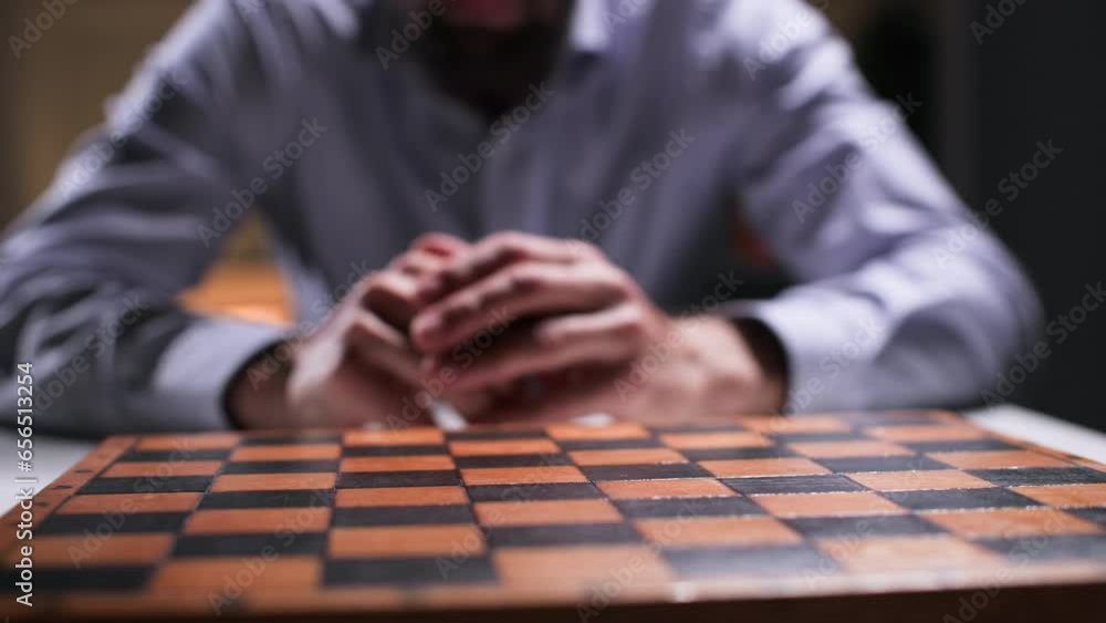 strategy and success concept, a young man sitting near a chessboard and a chess piece planning his next move, close-up strategy and success concept, a young man sitting near a chessboard and a chess piece planning his next move, close-up