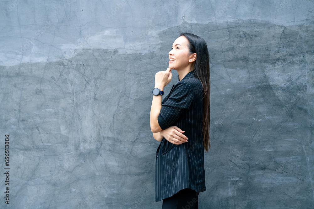 Fototapeta premium Portrait of successful business asian woman in black suit with smile isolated over blue background. Business stock photo.