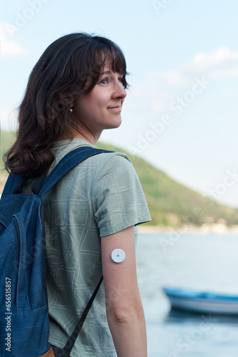 Happy Diabetic type 1 women enjoying nature with Abbott Freestyle Libre sensor on the arm for measuring blood sugar level. The latest technology for better life quality for a diabetic.