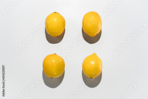 Fresh lemons on white background. Hard light isolated for pattern. Hard light top view. Fresh food and vitamin C in nutrition and skincare