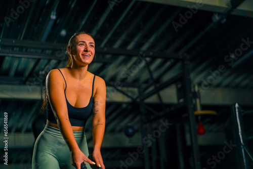 beautiful young fitness woman doing exercises with a rope in her hands in the gym preparing for a bodybuilding competition motivation