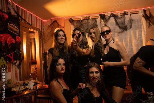 European Halloween party in a friends apartment- -Images of Young adults celebrating Halloween. photo