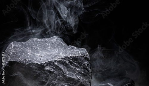 Mountain rock and floating smoke on a black background are for displaying product