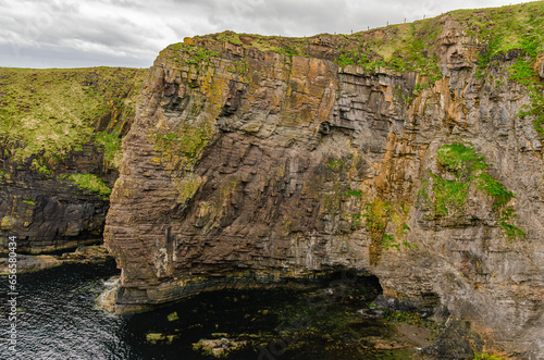 Mountain rock face hanging over the sea in Scotland. Torridonian Sandstone photo