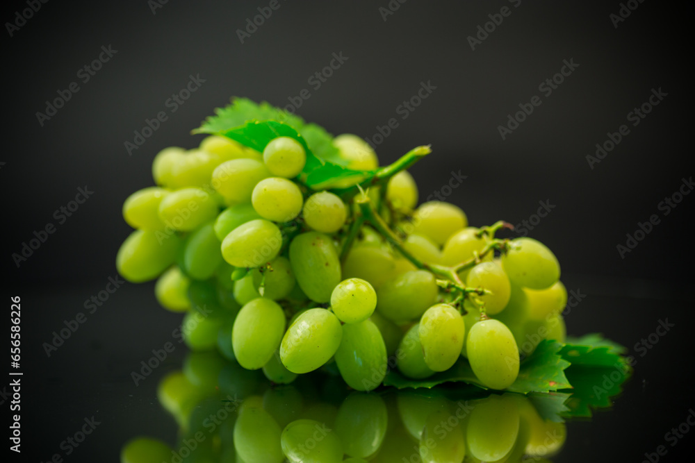 A bunch of ripe green grapes with leaves.