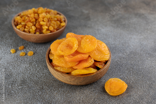 Bowls of golden raisins and dried apricot on a gray background. Copy space.