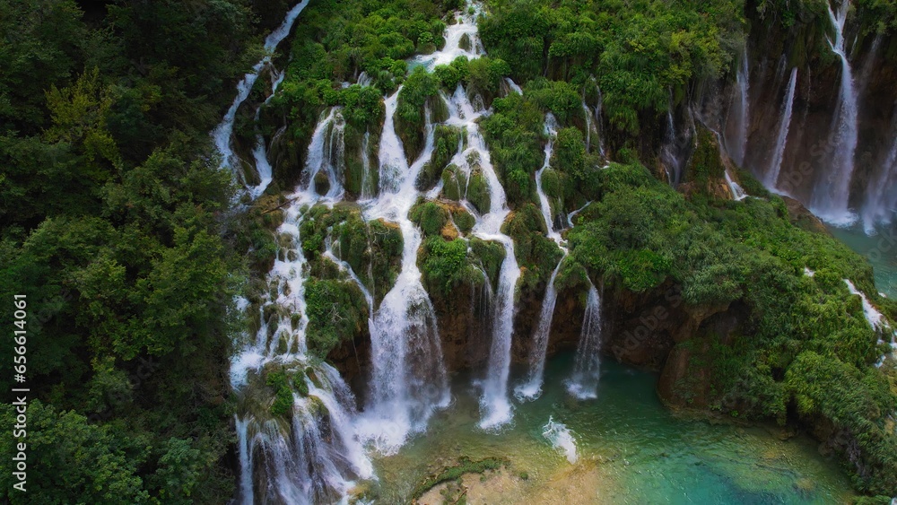Fototapeta premium Tropical forest and mountain landscape with streams of water and waterfalls. Cascades flow among lush greenery in spring or summer.