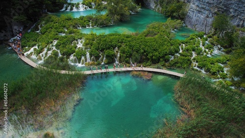 Hiking trail over crystal clear emerald water of lake. Path for tourists in mountain national park with waterfalls.