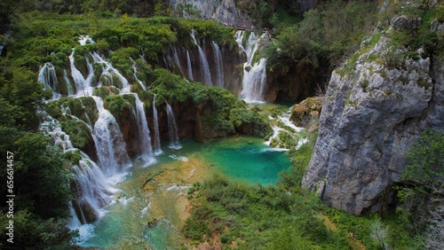 Beautiful waterfall in green forest, aerial top down view. Summer mountain landscape. Famous landmark and tourist attraction.