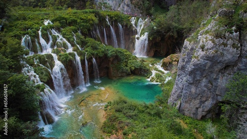 Beautiful waterfall in green forest  aerial top down view. Summer mountain landscape. Famous landmark and tourist attraction.