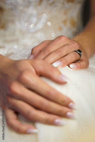 hands of the bride with white fingernails and jewerlery photo