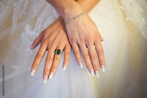 hands of the bride with white fingernails and jewerlery photo