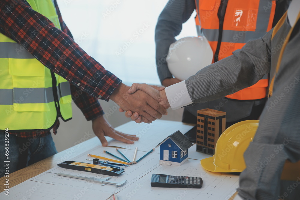 Construction and structure concept of Engineer or architect meeting for project working with partner and engineering tools on model building and blueprint in working site, contract for both companies. Construction and structure concept of Engineer or architect meeting for project working with partner and engineering tools on model building and blueprint in working site, contract for both companies.