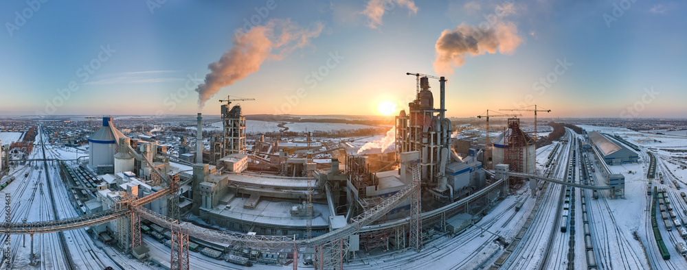 Aerial view of cement factory with high concrete plant structure and tower crane at industrial production area in evening. Manufacture and global industry concept - obrazy, fototapety, plakaty 