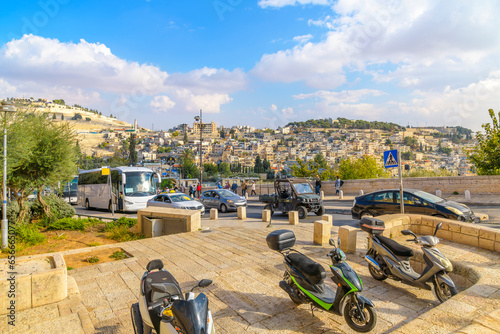 Residential buildings can be seen from alongside the busy streets full of pedestrian and traffic alongside the Temple of the Mount in the historic old city of Jerusalem, Israel. photo