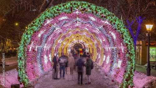 Timelapse of the decorated light tunnel on Tverskoy Boulevard during a winter holiday night in Moscow, with people walking inside photo