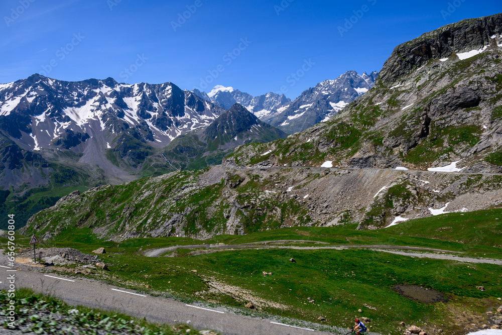 Narrow mountains road from Col de Lautaret to Col du Calibier, Mountains and alpine meadows views of Massif des Ecrins, Hautes Alpes, France in summer