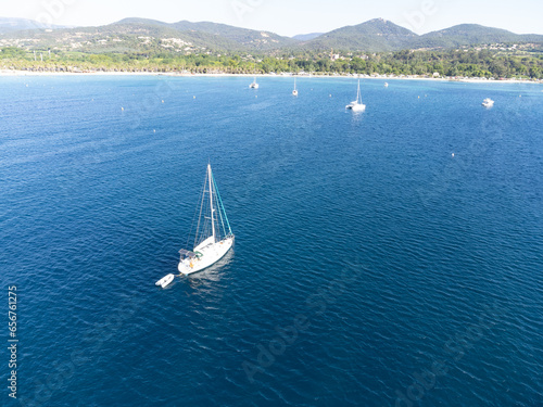 Aerial view on blue water of Gulf of Saint-Tropez, sail boats, houses of Port Grimaud, Port Cogolin, summer vacation in Provence, France