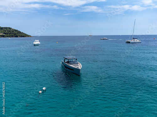Aerial view on boats, crystal clear blue water of legendary Pampelonne beach near Saint-Tropez, summer vacation on white sandy beach of French Riviera, France