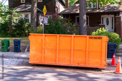 Εκτύπωση καμβά A roll-off construction dumpster parked on a residential street with traffic cones on a shady street in an older neighourhood