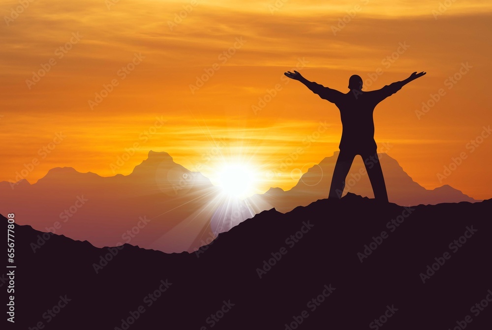 Man standing on top of mountain arms raised successfully