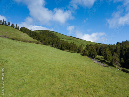 Aerial view of a beautiful green meadow in the mountains under a blue sky in the place of Sete Cidade, Island of Sao Miguel in the Azores